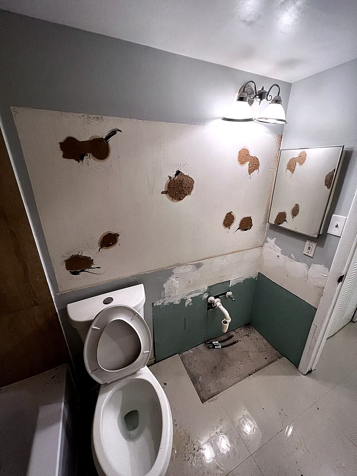 Bathroom before the refresh with patched walls and the vanity removed in Hollywood