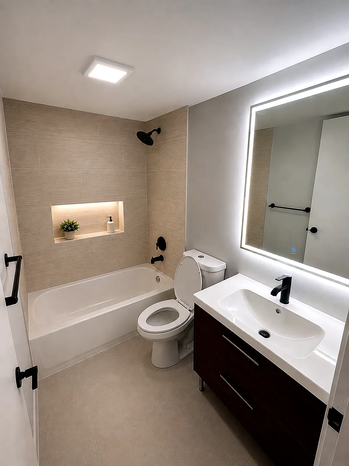 Second bathroom after the refresh, with new tile surround, lit niche, floating vanity, LED mirror and black fixtures in Hollywood