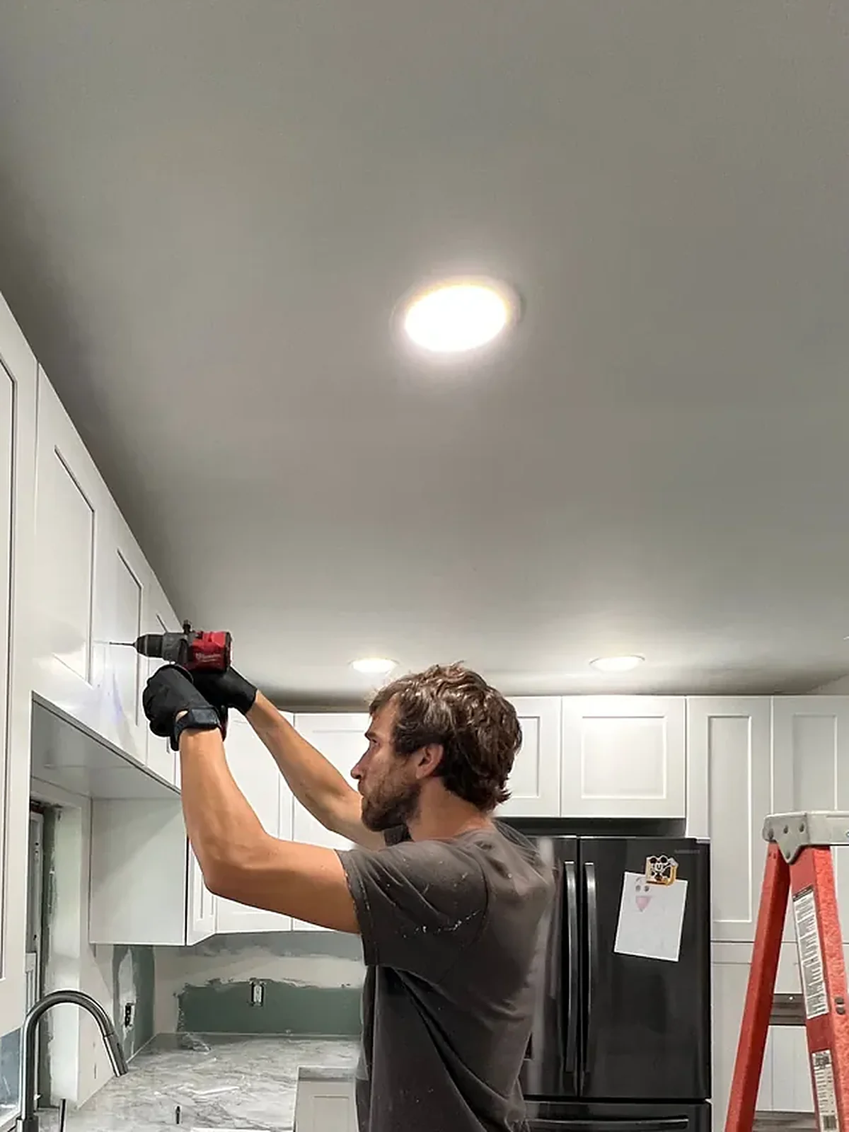 Installing kitchen wall cabinets during a kitchen refresh in Miami