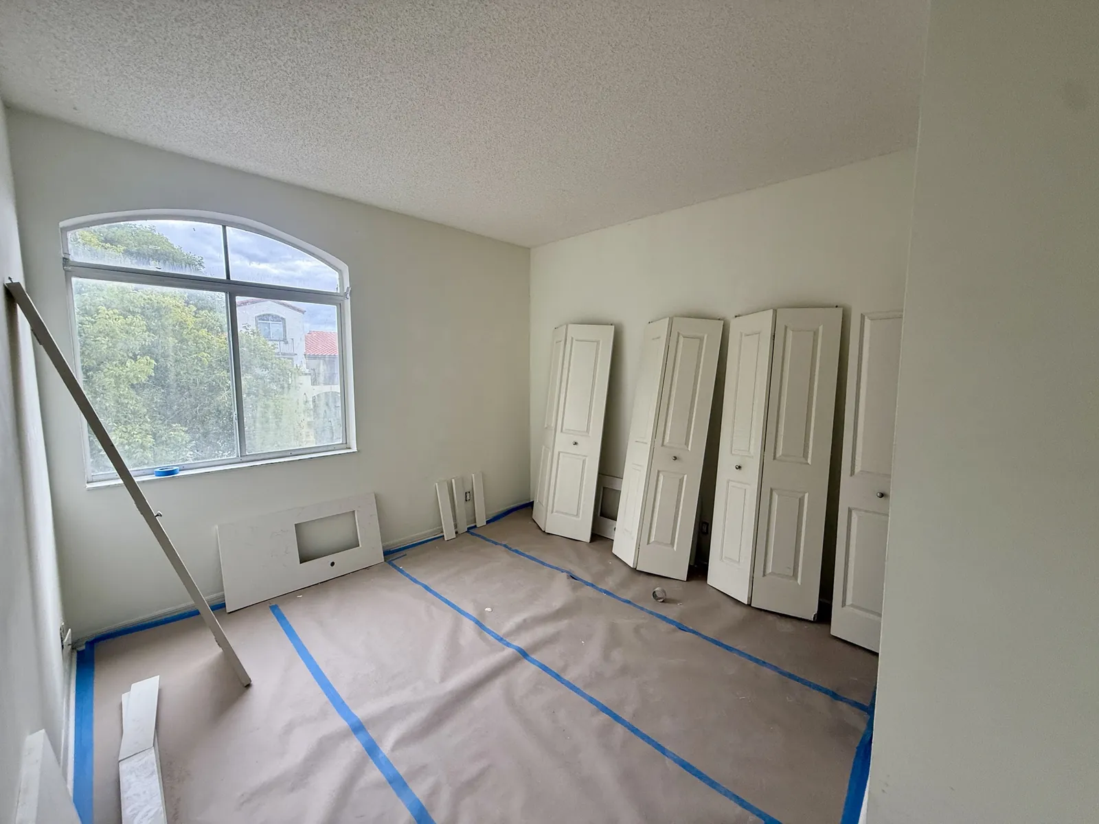 Bifold closet doors removed for spray finishing during an interior painting job in Miami