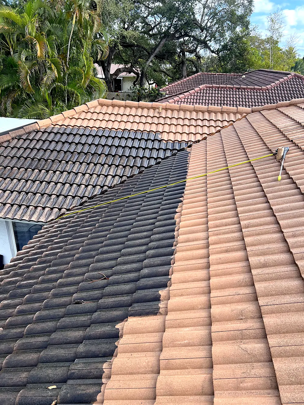 Barrel tile roof half pressure washed, showing the cleaned section beside the untreated one in Miami