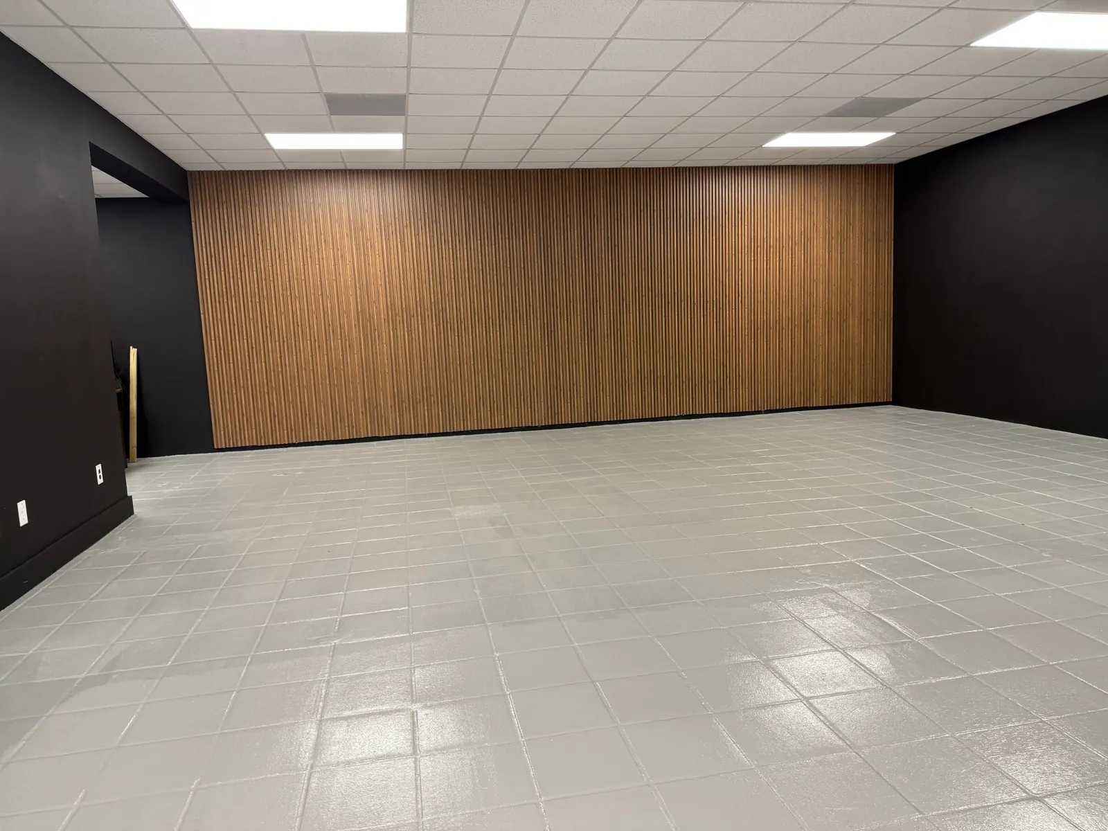 Wood slat feature wall with black painted walls and coated floor in Miami